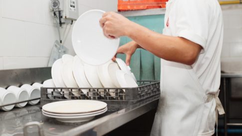 Restaurant worker washes dishes