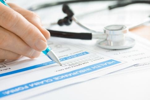 Doctor completing a medical insurance claim form