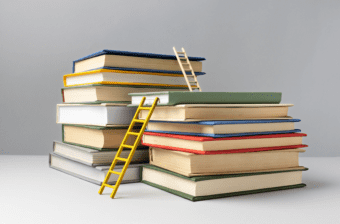 Stacks of books with ladders representing primary, secondary, and higher education in the U.S.