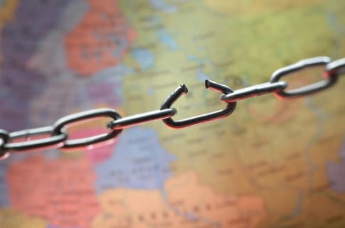 A broken chain over a map represents supply chain chaos