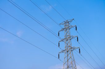 High voltage electricity pylon on blue sky